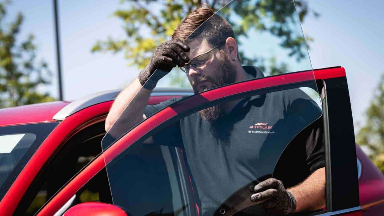 An Autoglass technician replacing a side window
